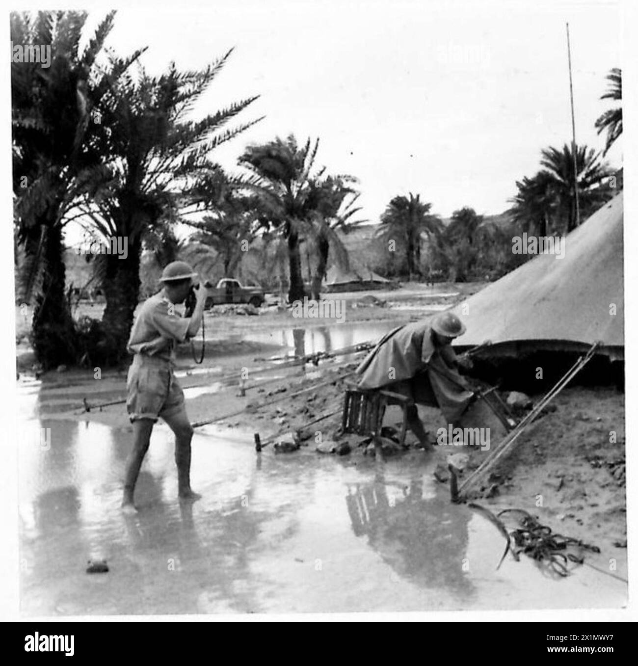 Ein offizieller Fotograf navigiert durch überflutete Gebiete in Tobruk, um Bilder für die britische Armee aufzunehmen. Stockfoto