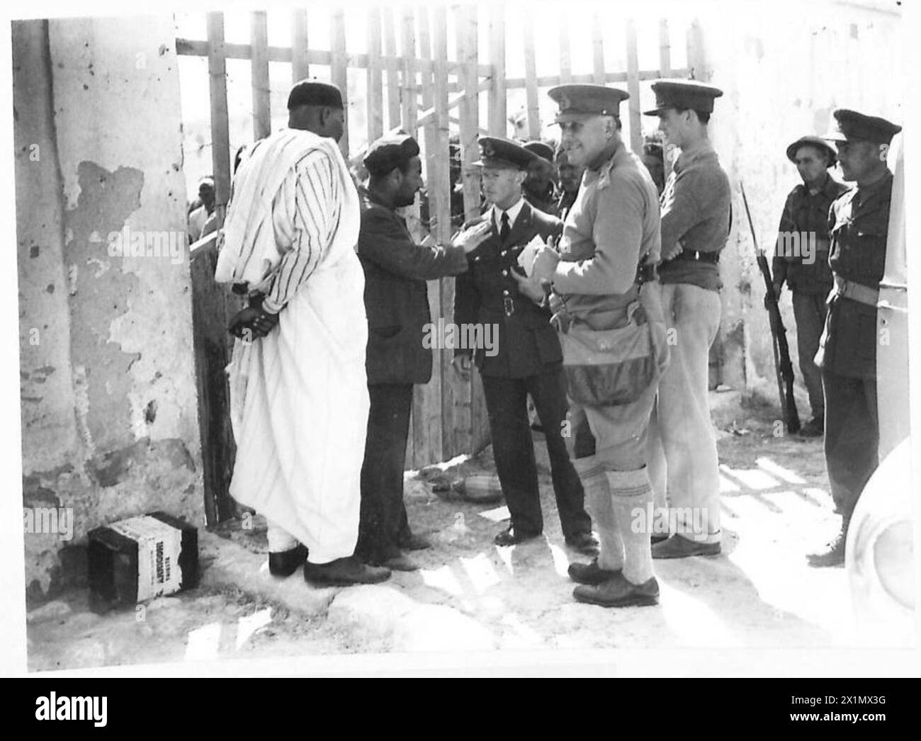 LIEUT. GENERAL SIR HENRY MAITLAND WILSON, DER GOUVERNEUR VON CYRENAIKA, BESUCHT WESTLICHSTE GEBIETE VON CYRENAIKA, LIBYEN - LIEUT. General Sir Henry Maitland Wilson, mit einigen einheimischen Häuptern eines Dorfes nach einem Gespräch. Mit dem General ist Major Burges Watson, politischer Offizier der Western Cyrenaica (in R.A.F. Uniform), British Army Stockfoto