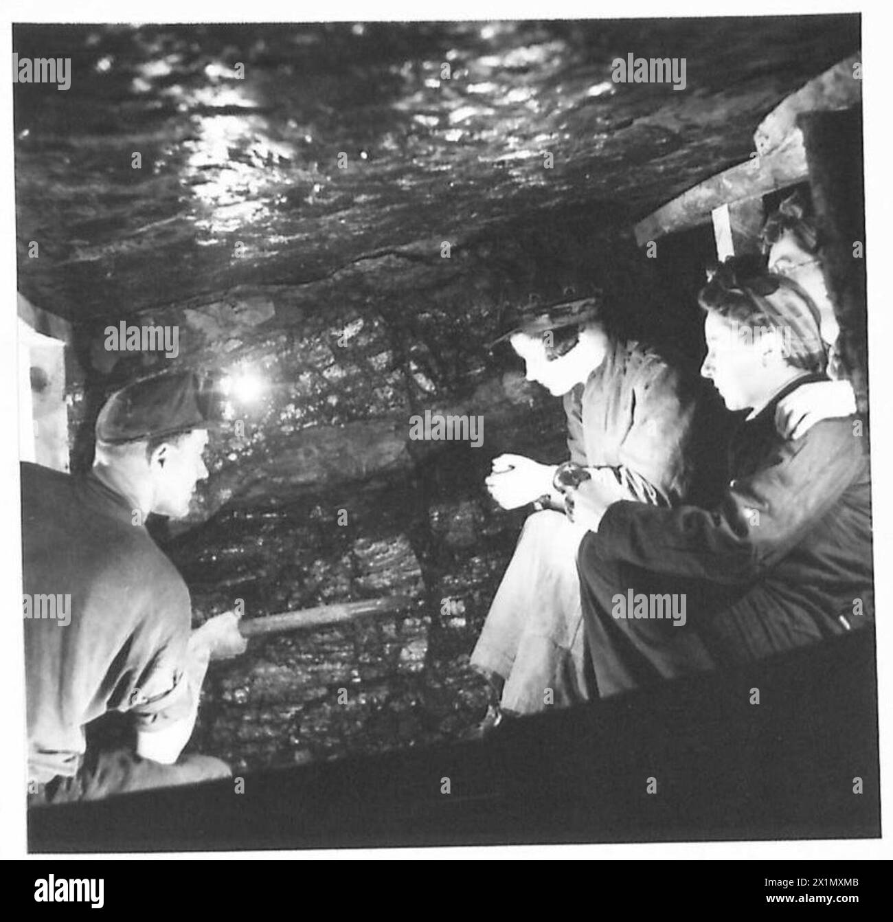 ATS-HILFSKRÄFTE BESUCHEN DIE SCHOTTISCHE KOHLEMINE - ATS-Hilfskräfte beobachten einen Bergarbeiter bei der Arbeit im Kohlegesicht der British Army Stockfoto