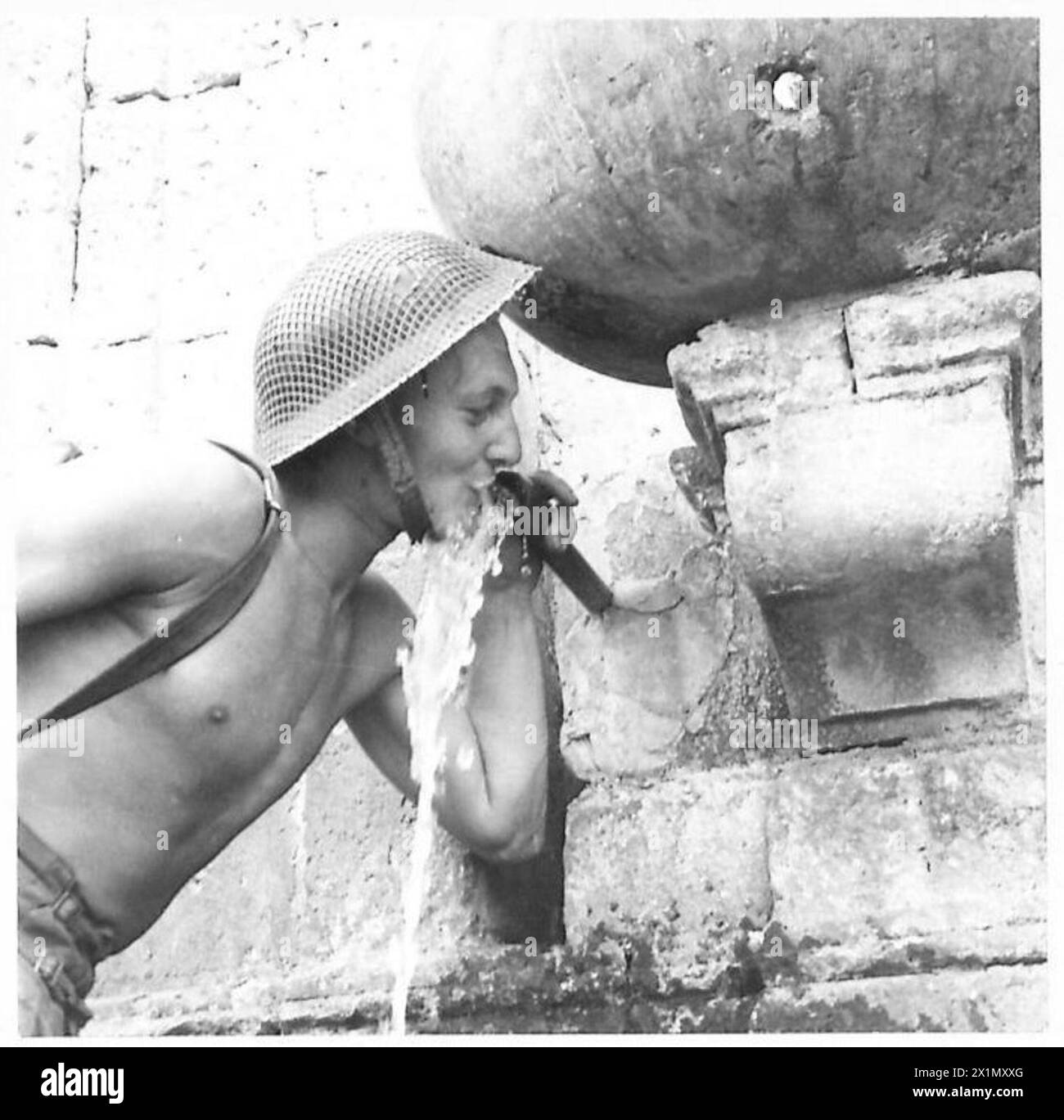 INVASION SIZILIENS - L/CPL. Cooper of Middleton, Lancs, trinkt aus dem Dorfbrunnen in Vallasmunster, britische Armee Stockfoto