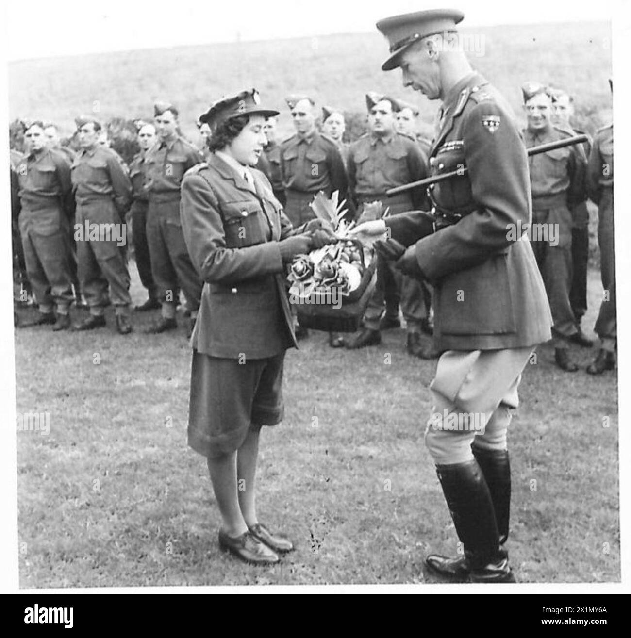 PRÄSENTATION DES BECHERS FÜR den besten ARMEEGARTEN IM SÜDKOMMANDO - privater F.L. Fisher A.T.S. präsentiert Lieutenant General Loyd mit einem Korb mit Gemüse, das von der Einheit der britischen Armee angebaut wurde Stockfoto