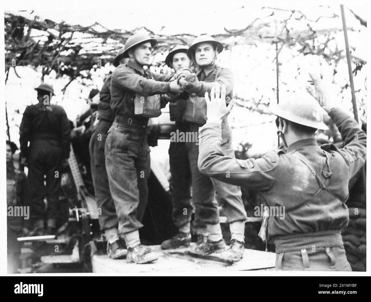 Neufundland-Schützen der britischen Armee laden eine Granate in die Öffnung eines 6-Zoll-Howitzer-Artilleriegeschosses. Stockfoto