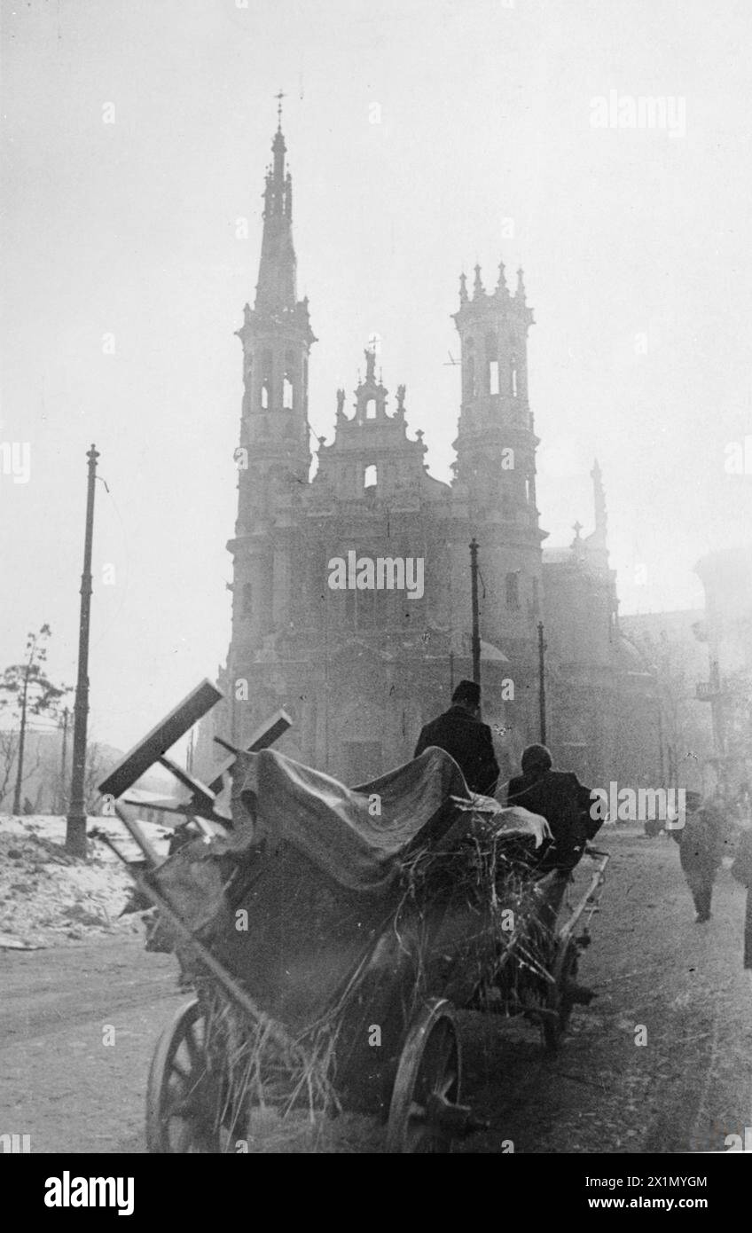 DIE ZERSTÖRUNG VON WARSCHAU, 1944 – die Bewohner von Warschau ziehen einen großen Wagen mit ihren Sachen, als sie nach der „Befreiung“ der Stadt durch die Rote Armee im Februar 1945 in ihre Häuser zurückkehren. Sie nähern sich der Kirche des heiligsten Erlösers (Kościół Najświętszego Zbawiciela) auf dem Erlöserplatz (Plac Zbawiciela) im Stadtzentrum von Warschau, Stockfoto