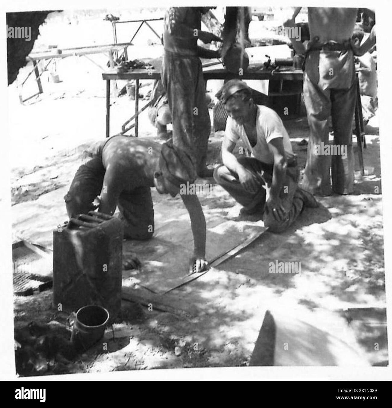 Handwerker Wentwork aus London schneidet Blech vor dem kombinierten Betrieb in wasserdichte Honigtanks und veranschaulicht die Vorbereitung und Wartung der Betriebsmittel. Stockfoto