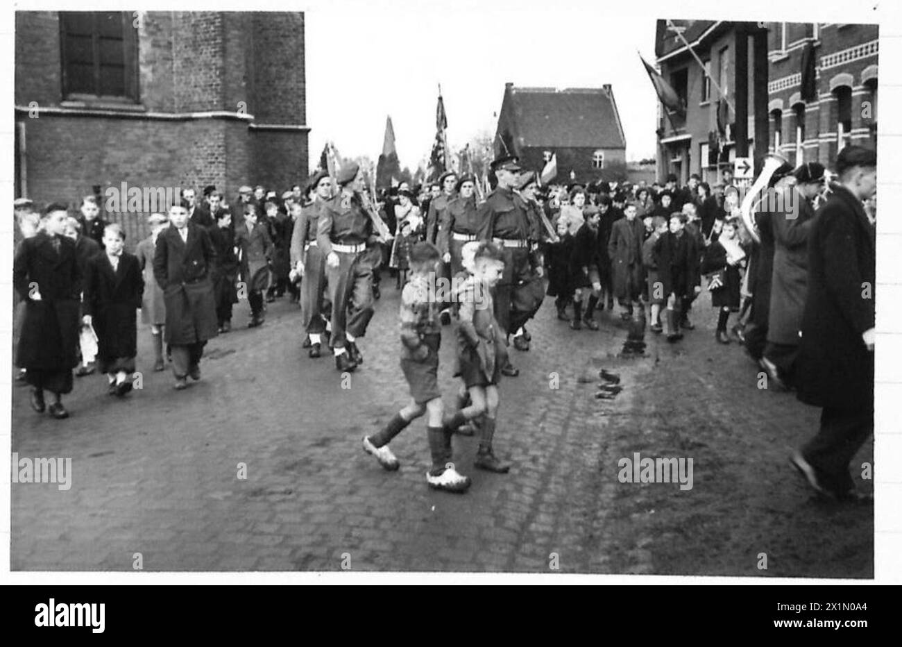 TAG DES WAFFENSTILLSTANDS IM DORF BOCHOLT. - Die Zivilbande und die Ehrenwache marschieren zum Friedhof, britische Armee, 21. Armeegruppe Stockfoto