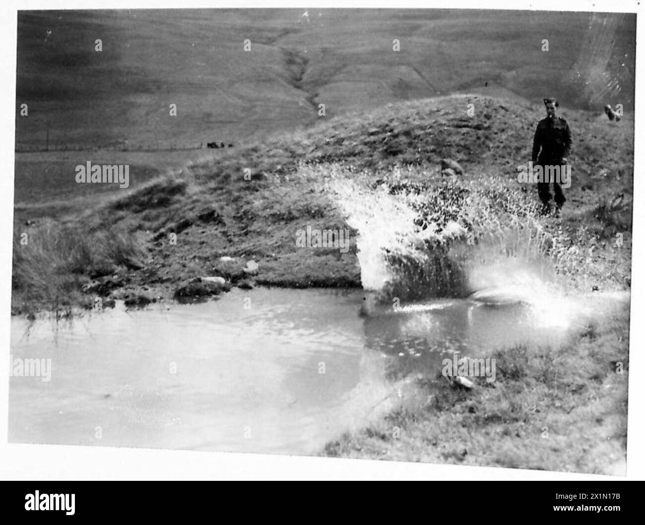 Ein Wettkämpfer reitet durch ein Wasserhindernis während eines Rough Riding Events in Schottland, British Army. Stockfoto