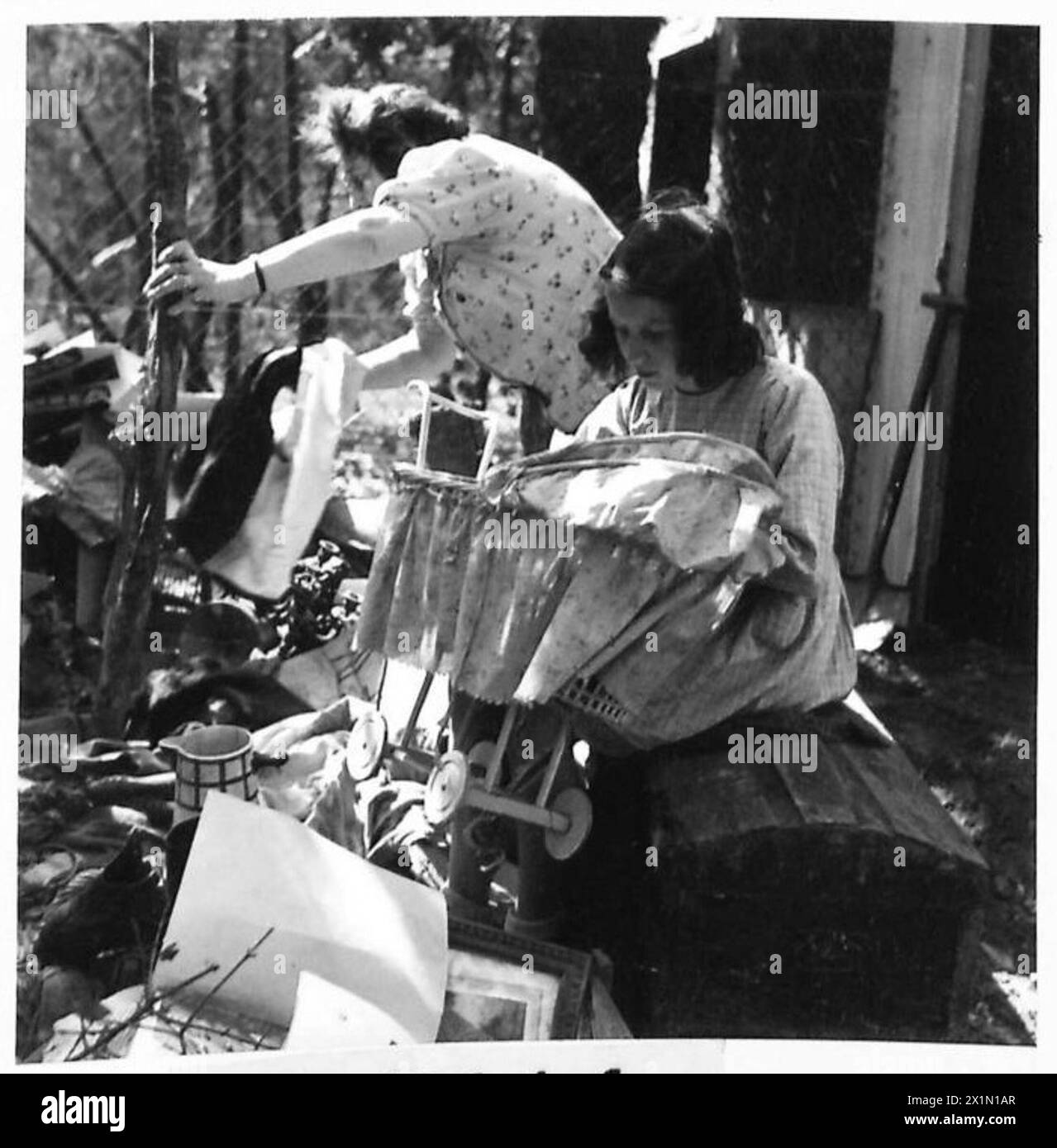 Eine französische Familie entdeckt bei ihrer Rückkehr begrabene Wertsachen, wobei Camille während der Operationen der britischen 21. Armee den Kinderwagen ihrer Puppe intakt findet, während die Puppe vermisst wurde. Stockfoto