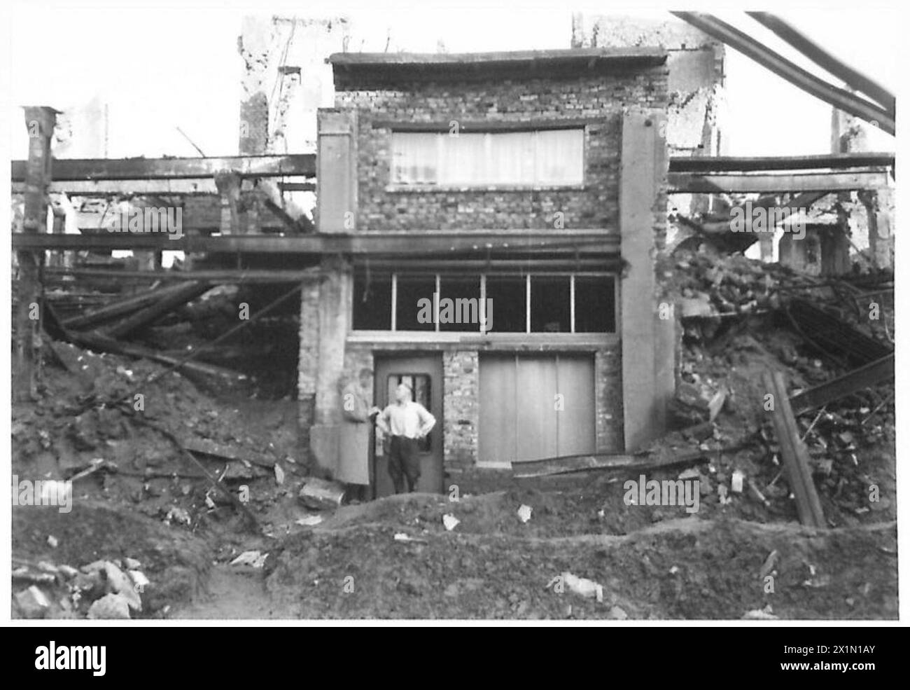 DIE PRODUKTION Einer ZEITUNG IN DEUTSCHLAND - Chefreporter Richard Kraske - befragt Herrn Grundmann, einen Dortmunder Bürger, der zweimal bombardiert wurde und nun ein Haus innerhalb der Mauern eines anderen Gebäudes, der britischen Rheinarmee, gebaut hat Stockfoto