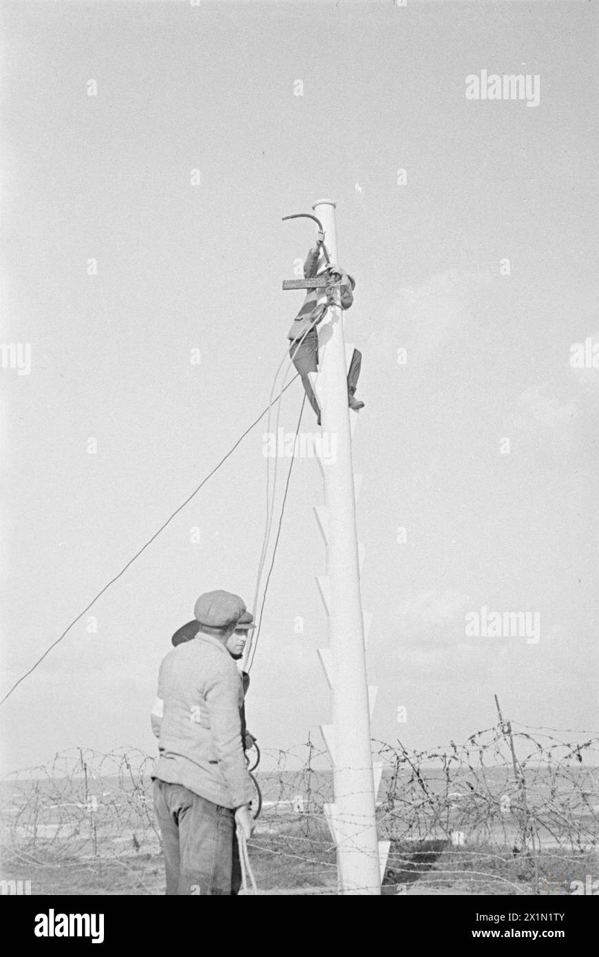 1940 führte eine Station der East Coast Coastguard eine Rettungsübung mit Raketen und Reisetoje durch, wobei Freiwillige einen Peitschenblock am Masthead befestigen und mehrsprachige Anweisungen befolgten. Stockfoto