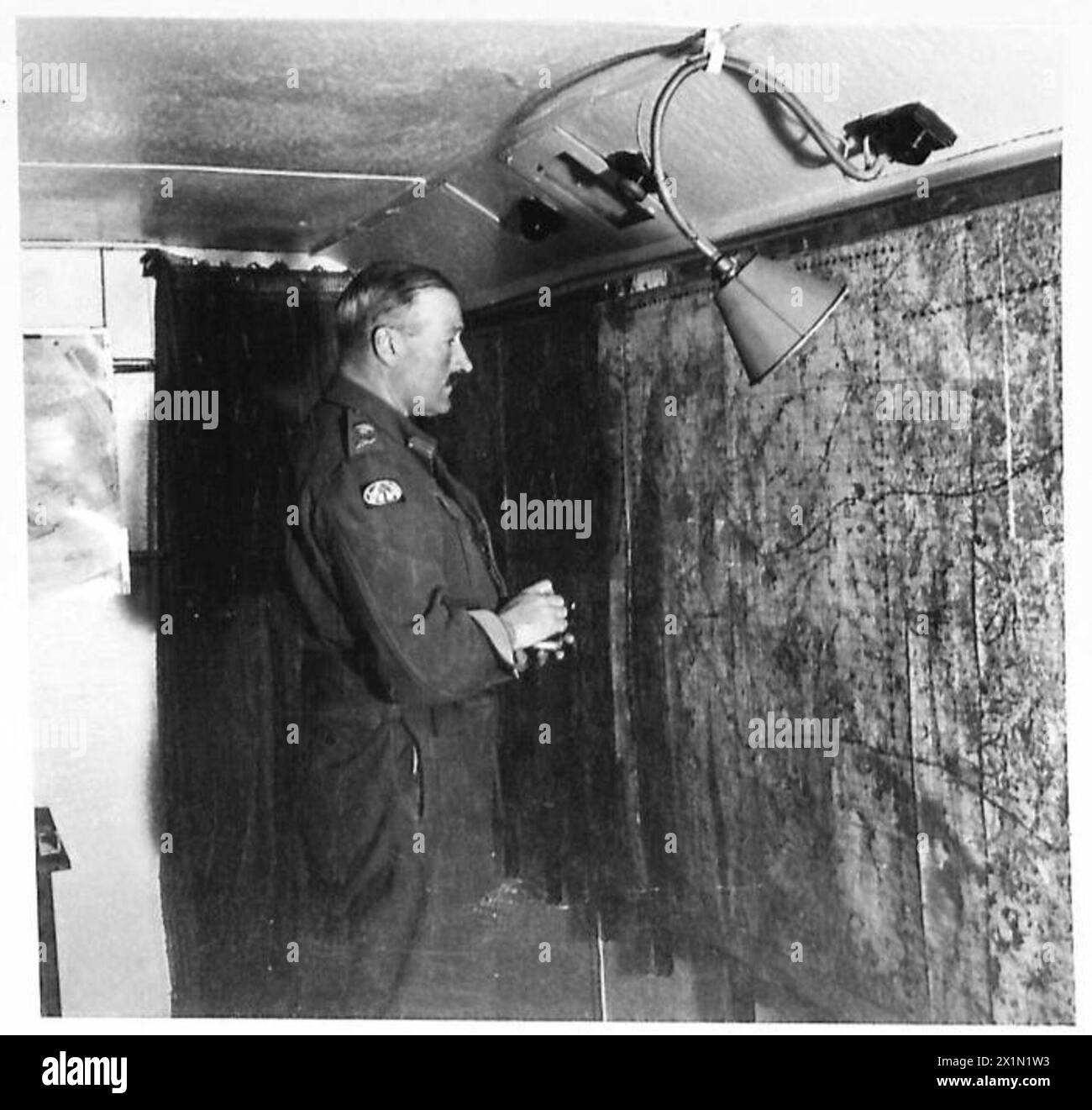 General Ritchie überprüft Karten, die die Wände seines Hauptquartiers in Frankreich, der britischen Armee, der 21. Armeegruppe abdecken. Stockfoto