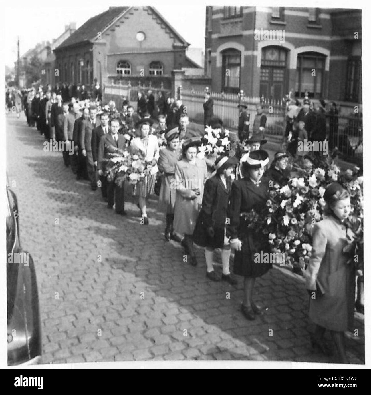 Die Trauernden folgen dem Sarg des Anführers der Belgischen Weißen Brigade zur Pfarrkirche während einer Beerdigung der 21. Armee der britischen Armee. Stockfoto