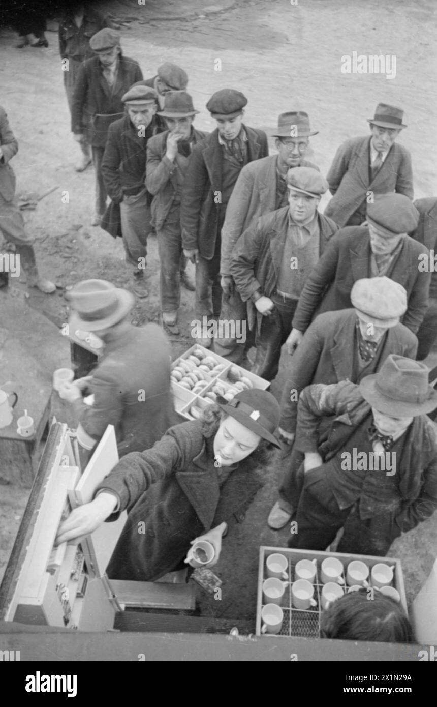 Patience 'Boo' Brand des Women's Voluntary Service holt Zigaretten aus einem WVS-Teeauto für Männer ab, die in London Tee und Brötchen kaufen, nachdem sie Trümmer von einem Luftangriff von 1941 geräumt haben. Stockfoto