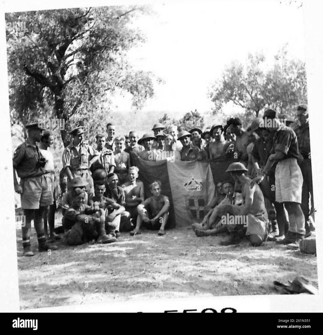 Offiziere und Soldaten der 1. Dorsets gehören zu den ersten britischen Truppen, die Regalbuto, Sizilien, einmarschierten und die eroberte Stadtflagge trugen. Stockfoto