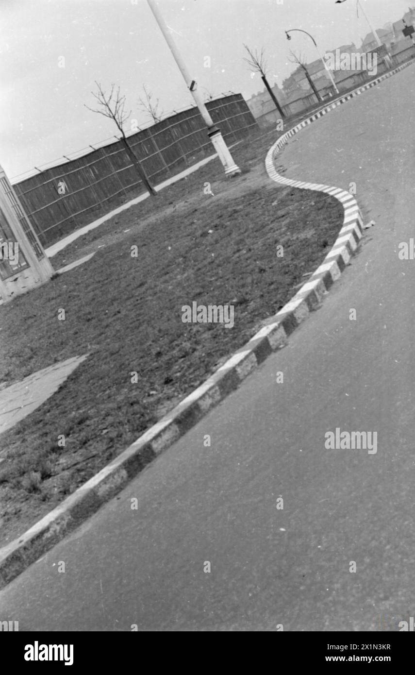 Schwarz-weiße Streifen oder Blöcke, die auf einem gewundenen Bordstein in London gemalt sind, heben den Vorteil des Fahrers bei Verdunkelungsbedingungen hervor. Stockfoto