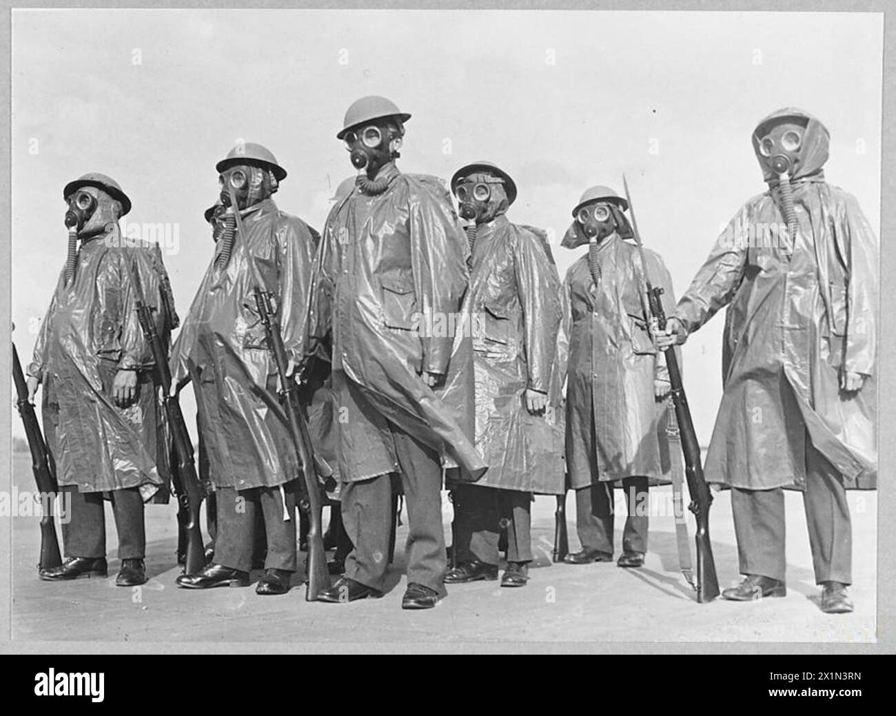 RAF-Mitarbeiter tragen während des Gewehrtrainings auf britischen Stationen Anti-Gas-Umhänge und Atemschutzmasken, was die Bereitschaft zum chemischen Krieg demonstriert, Royal Air Force, 1940-1945. Stockfoto
