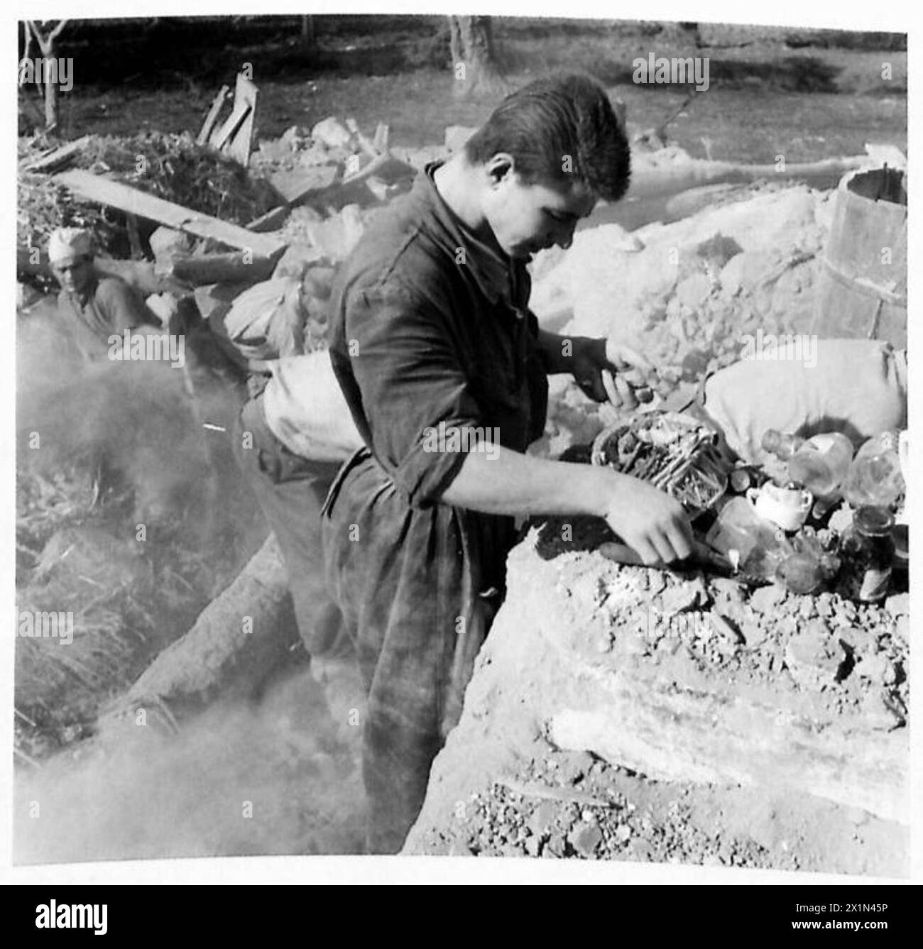 An der Fünften Armeefront in Italien sammelt ein Cousin eines Opfers kleine persönliche Gegenstände, die eine deutsche Gräueltat überlebt haben, die von der britischen Armee dokumentiert wurde. Stockfoto
