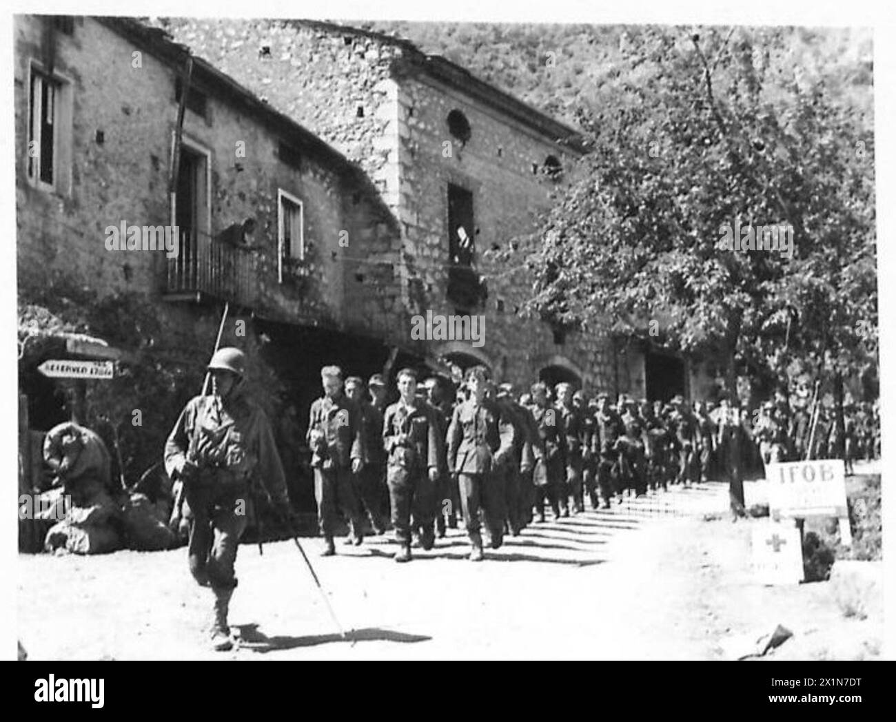 Deutsche Gefangene marschieren durch Esperia unter der Wache eines Soldaten der Freien Französischen Division während des Vormarsches der Fünften Armee gegen die Hitlerlinie, die britische Armee. Stockfoto