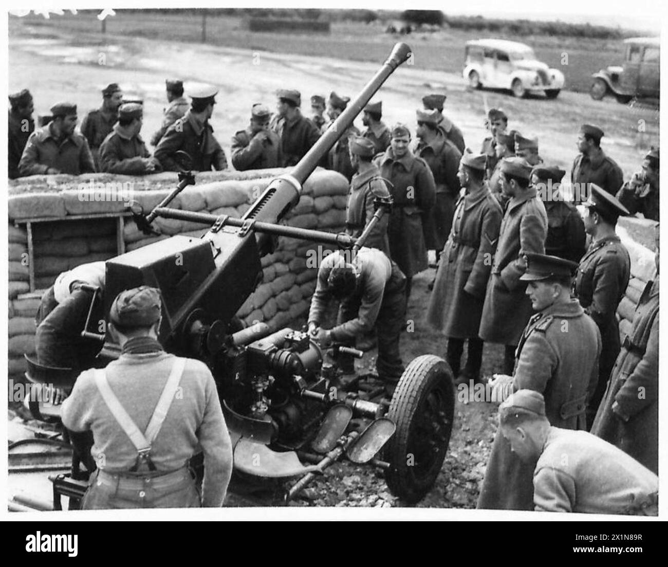 Griechische Soldaten werden im Betrieb von britischen leichten Flugabwehrkanonen unterrichtet, wobei sie die Vorbereitungsverfahren unter der Leitung der britischen Armee beobachten. Stockfoto Griechische Soldaten werden im Betrieb von britischen leichten Flugabwehrkanonen unterrichtet, wobei sie die Vorbereitungsverfahren unter der Leitung der britischen Armee beobachten. Stockfoto