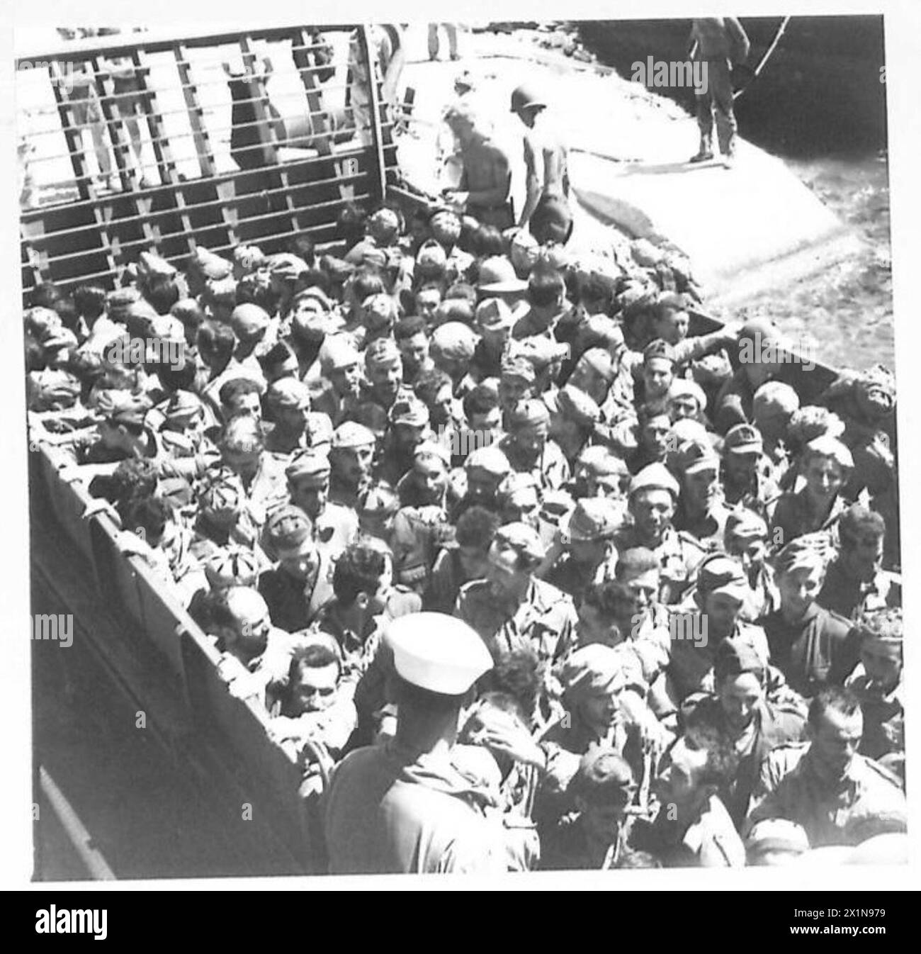 GEFANGENE AUS SIZILIEN STEIGEN IN BIZERTA IN NORDAFRIKA AUS - Bootsladung von Gefangenen, die am Hafen festgebunden sind, britische Armee Stockfoto