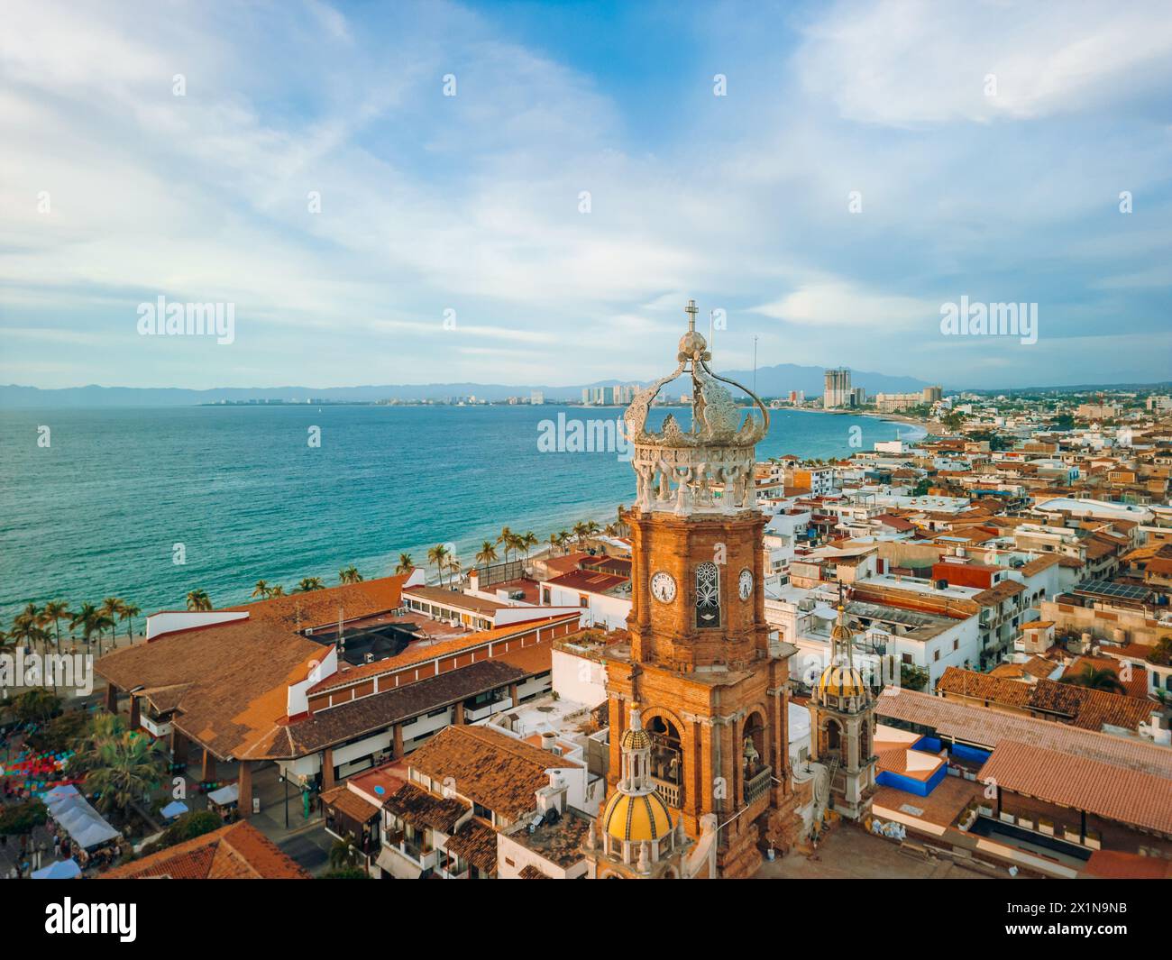 Aus der Vogelperspektive auf die Kirche unserer Lieben Frau von Guadalupe in Puerto Vallarta, Mexiko und das Meer zur goldenen Stunde. Stockfoto