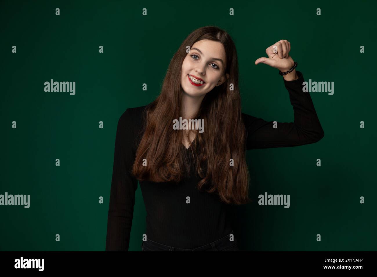 Frau posiert vor grünem Hintergrund Stockfoto