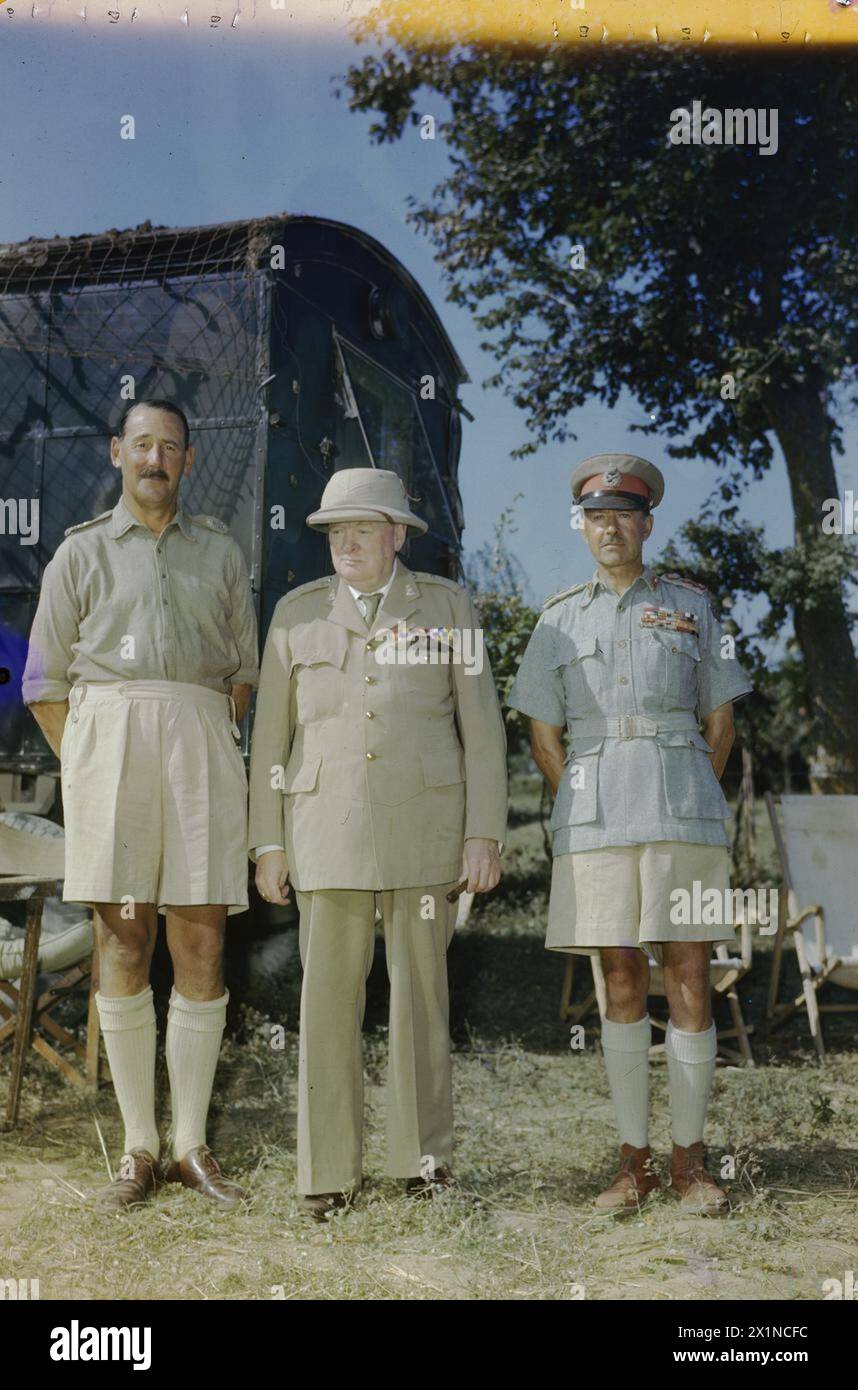 WINSTON CHURCHILL IM HAUPTQUARTIER DER ACHTEN ARMEE IN ITALIEN, 26. AUGUST 1944 - der Premierminister, Rt Hon Winston Churchill, Abgeordneter, mit dem Befehlshaber der achten Armee, Generalleutnant Sir Oliver Leese (links) und dem Obersten alliierten Befehlshaber im Mittelmeer, General Sir Harold Alexander im Hauptquartier von General Leese bei Monte Maggio. Eine Karawane ist teilweise im Hintergrund zu sehen, Churchill, Winston Leonard Spencer, Alexander, Harold Rupert Leofric George, Leese, Oliver William Hargreaves, British Army Stockfoto