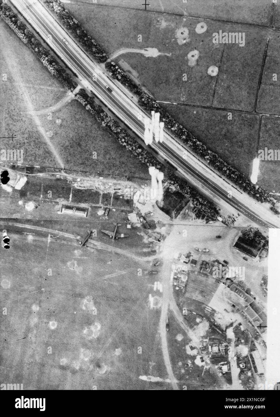 Luftaufnahmen zeigen Bristol Blenheim Mark IV., die den Flugplatz Ypenburg in Holland während der Schlacht von Frankreich 1939-1940 angreifen. 250-lb-Bomben treffen in der Nähe von geparkten Focke-Wulf FW 58-Flugzeugen mit Kratern von früheren Luftwaffenangriffen vor der deutschen Invasion. Stockfoto