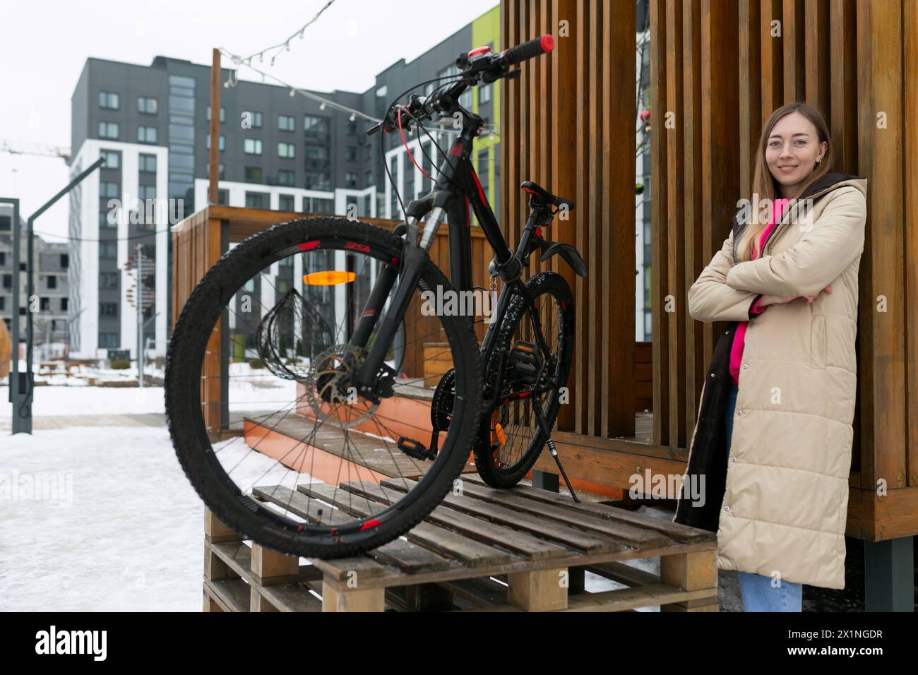 Frau, die neben dem Fahrrad auf Holzplattform steht Stockfoto