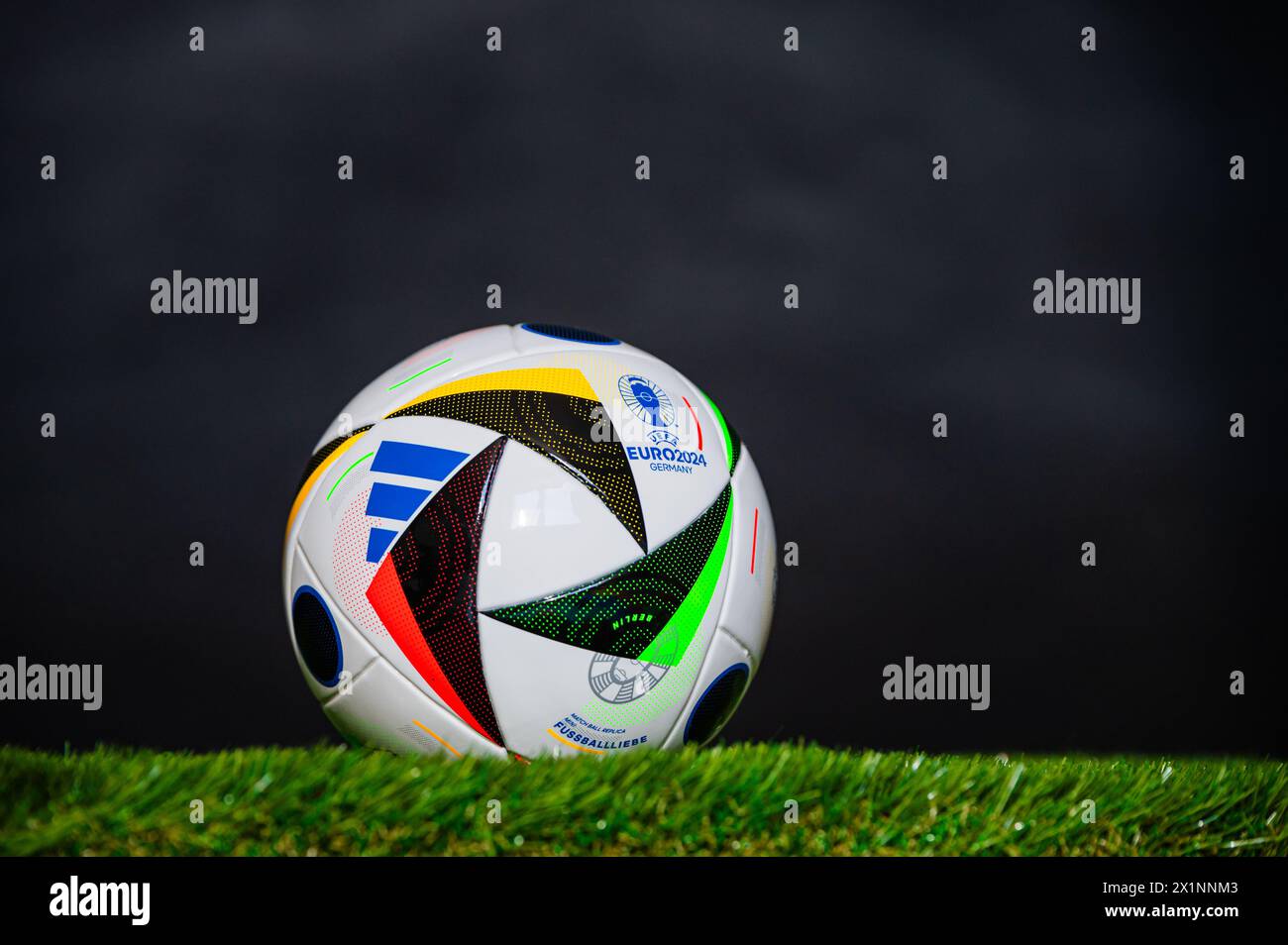 LEIPZIG, 17. APRIL 2024: Offizielle Adidas Fußball-Fussballliebe für die Fußball-Europameisterschaft 2024 auf grünem Gras. Schwarzer Hintergrund Stockfoto