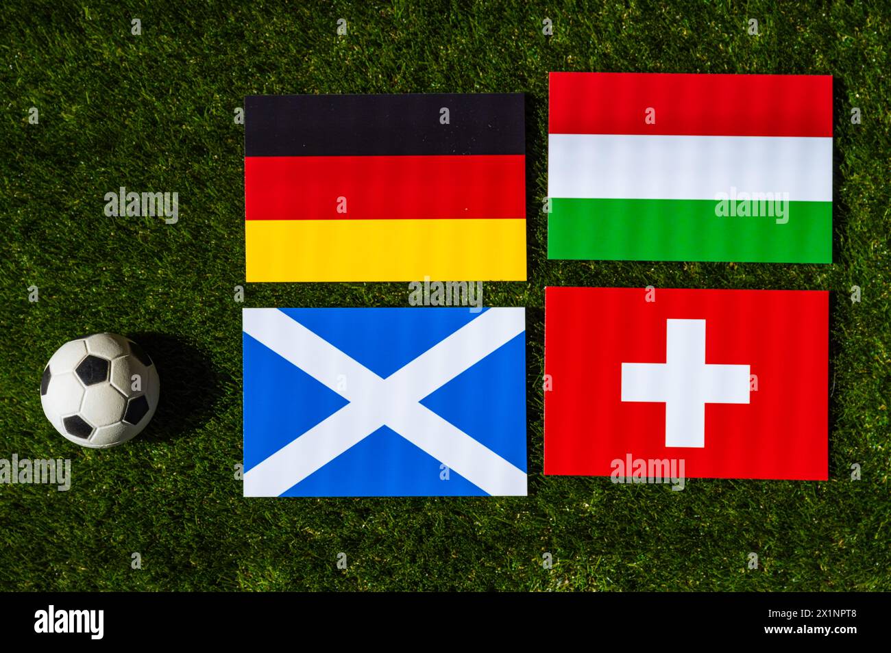 Deutschland führt Gruppe A an: Flaggen von Deutschland, Schottland, Ungarn, der Schweiz und Fußball auf grünem Gras beim Europa-Fußballturnier in Deutschland in 20 Jahren Stockfoto