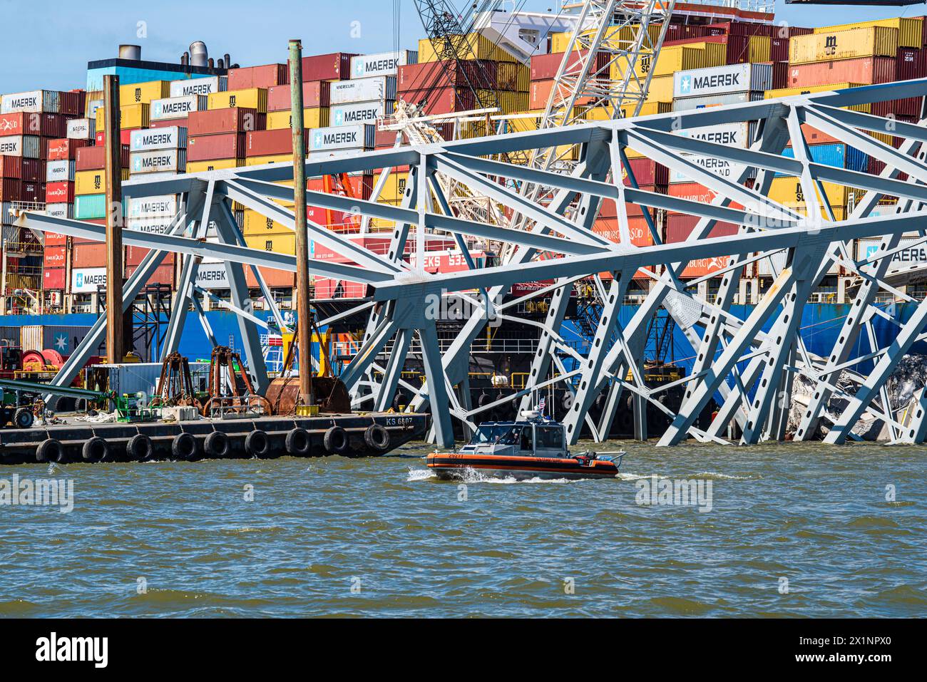 Dundalk, Vereinigte Staaten Von Amerika. April 2024. Dundalk, Vereinigte Staaten von Amerika. April 2024. Ein Patrouillenboot der US-Küstenwache passiert einen Abschnitt der eingestürzten Francis Scott Key Bridge, der den Kanal Fort McHenry blockiert, am 16. April 2024 in der Nähe von Dundalk, Maryland. Die Brücke wurde am 26. März von einem 984-Fuß-Containerschiff getroffen und stürzte zusammen, wobei sechs Arbeiter ums Leben kamen. Quelle: PO2 Ronald Hodges/US Coast Guard/Alamy Live News Stockfoto