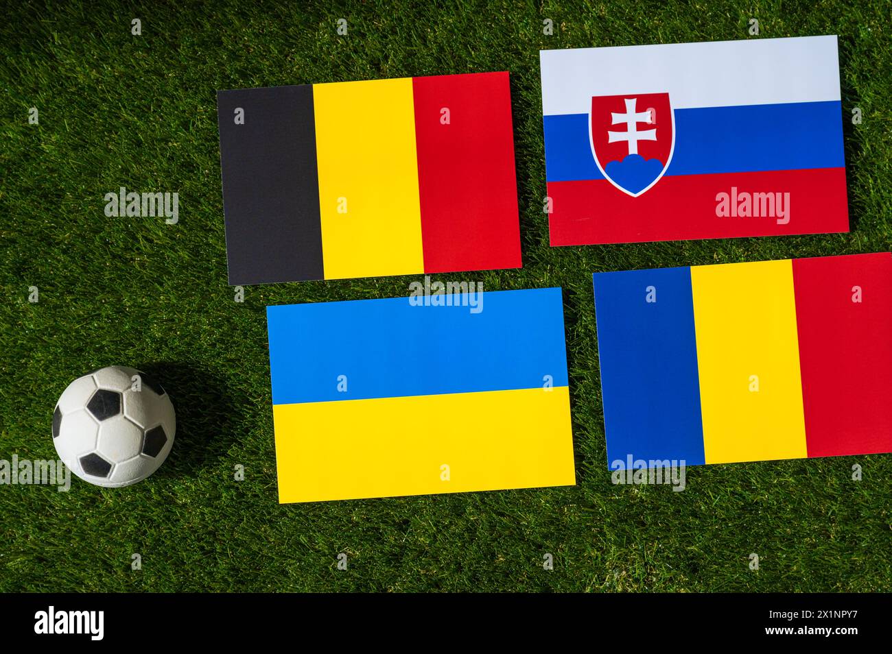 Belgien führt Gruppe E an: Flagge Belgiens, der Slowakei, Rumäniens, der Ukraine und Fußball auf grünem Gras beim Europaturnier in Deutschland im Jahr 2024 Stockfoto