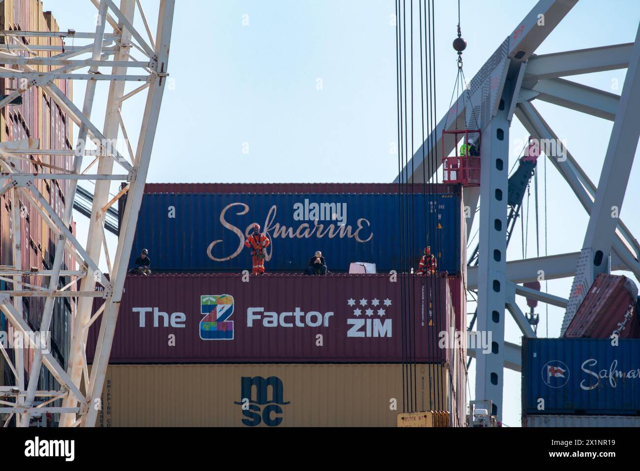 Dundalk, Vereinigte Staaten Von Amerika. April 2024. Dundalk, Vereinigte Staaten von Amerika. April 2024. Die Rettungskräfte des United Command weisen einen Lastkahnkran an, um Frachtcontainer vom Deck des eingeschlossenen MV Dali-Frachtschiffs abzuholen, das in Stahlträgern von der eingestürzten Francis Scott Key Bridge im Fort McHenry-Kanal am 16. April 2024 in der Nähe von Dundalk, Maryland, eingehüllt ist. Die Brücke wurde am 26. März von einem 984-Fuß-Containerschiff getroffen und stürzte zusammen, wobei sechs Arbeiter ums Leben kamen. Quelle: Dylan Burnell/US Army/Alamy Live News Stockfoto