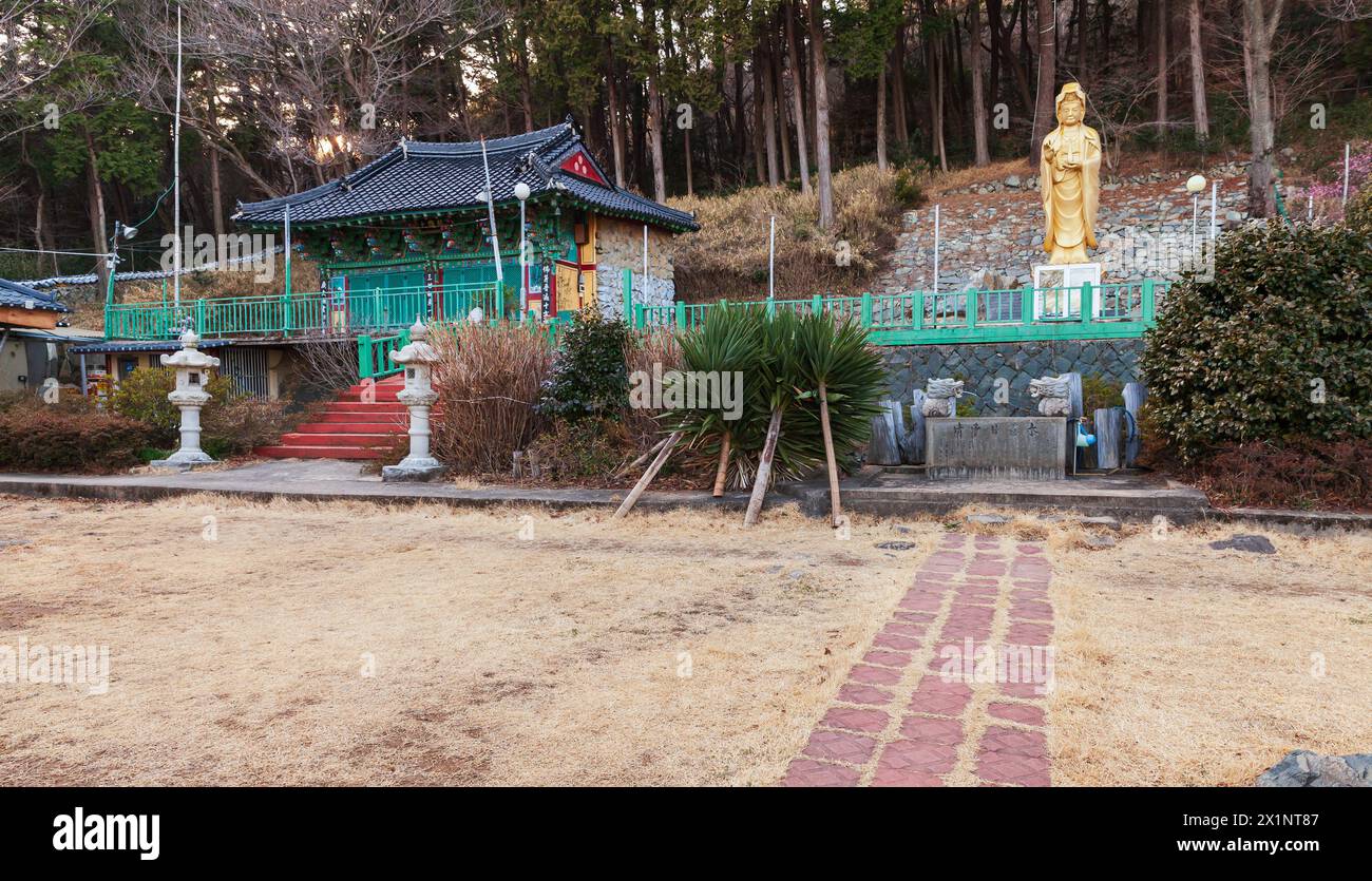 Buddhistischer Tempel von Janggunam mit goldener Buddha-Statue Busan. Chinesischer Text auf Stein bedeutet: Klares Wasser. Chinesischer Text auf Säulen bedeutet: Das Aroma Stockfoto
