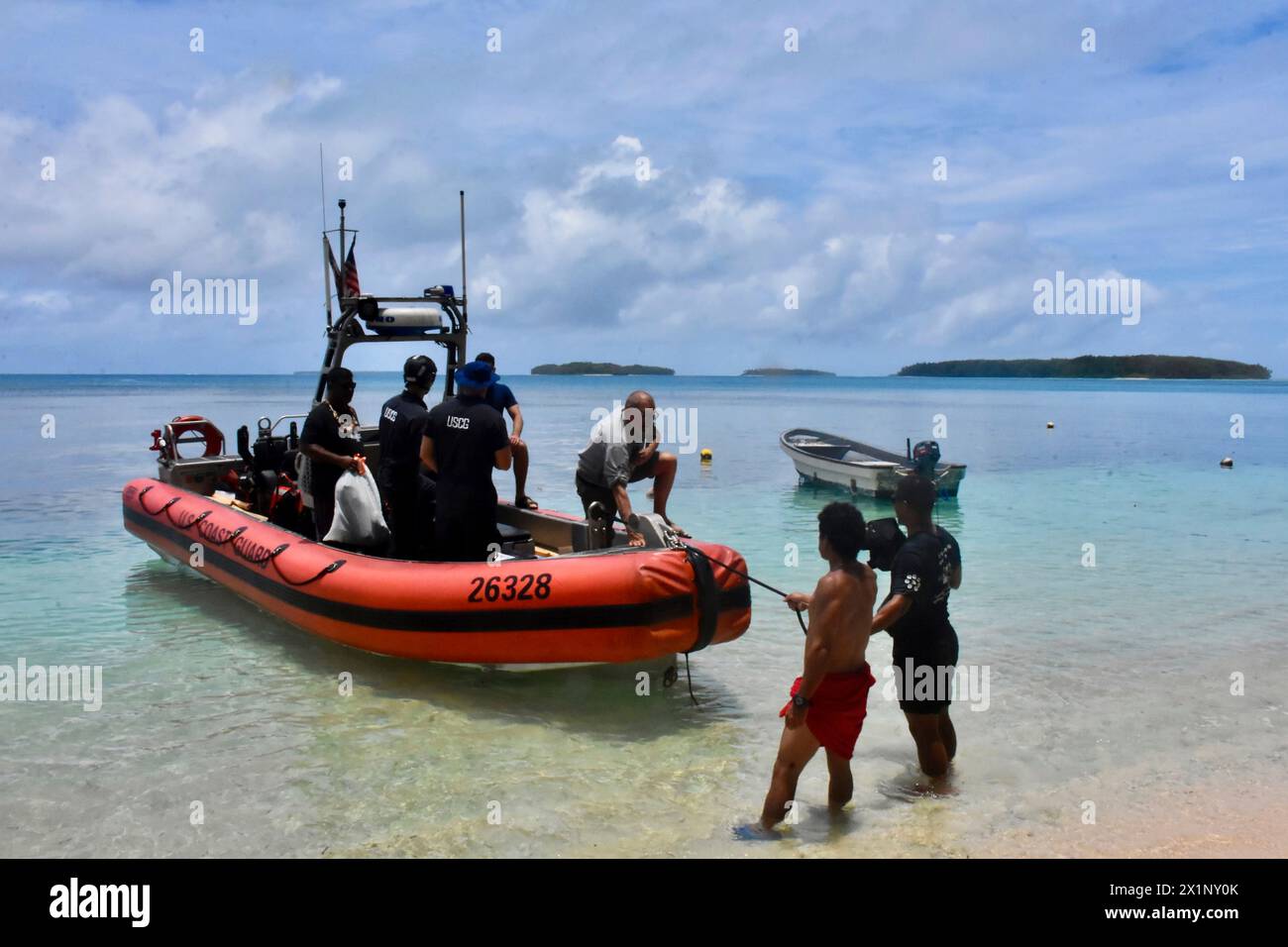 Woleai, Mikronesien, Föderierte Staaten Von. 12. April 2024. Die Besatzung des Schnellreaktionsschneiders USCGC Oliver Henry und die Anwohner entladen Frischwasser und ein Umkehrosmosesystem, um den Trinkwassermangel aufgrund der Dürre auf der abgelegenen Insel zu lindern, 12. April 2024 in Woleai, Yap State, Föderierte Staaten von Mikronesien. Quelle: CWO Sara Muir/USCG/Alamy Live News Stockfoto