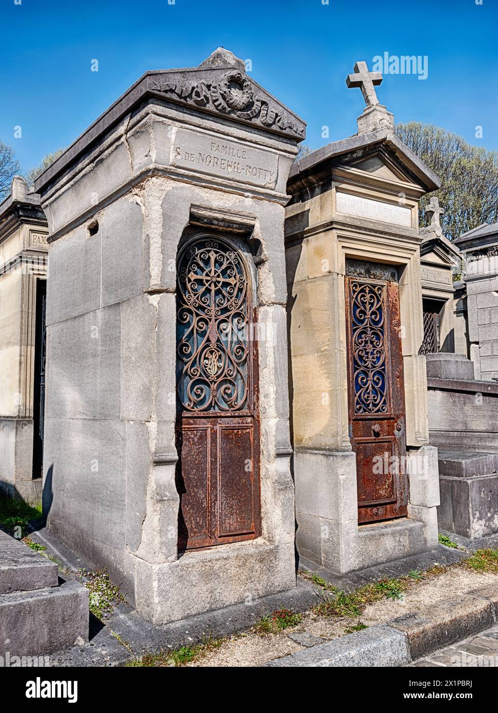 PARIS, FRANKREICH - 5. APRIL 2023: Zwei Familienkrypten stehen nebeneinander auf dem Friedhof Pere Lachaise in Paris. Stockfoto