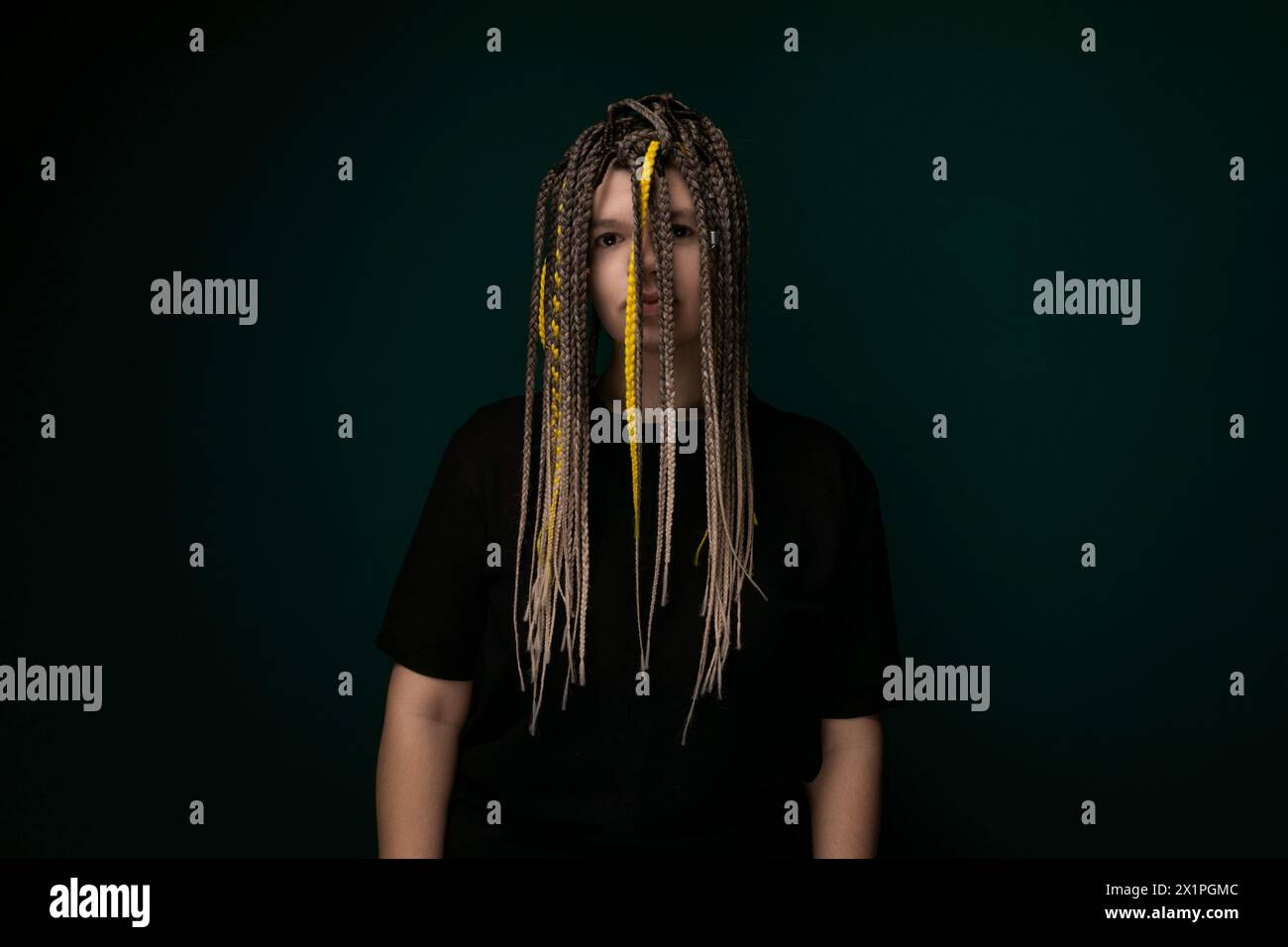 Mann mit Dreadlocks, der vor grünem Hintergrund steht Stockfoto