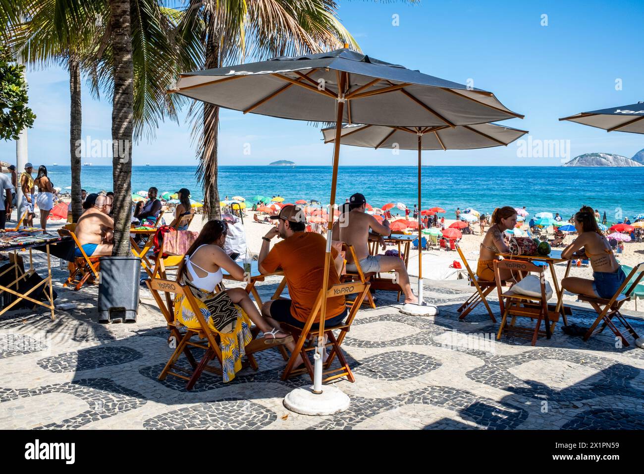 Besucher sitzen in einem Café/Bar im Freien am Strand von Ipanema, Ipanema, Rio de Janeiro, Brasilien. Stockfoto