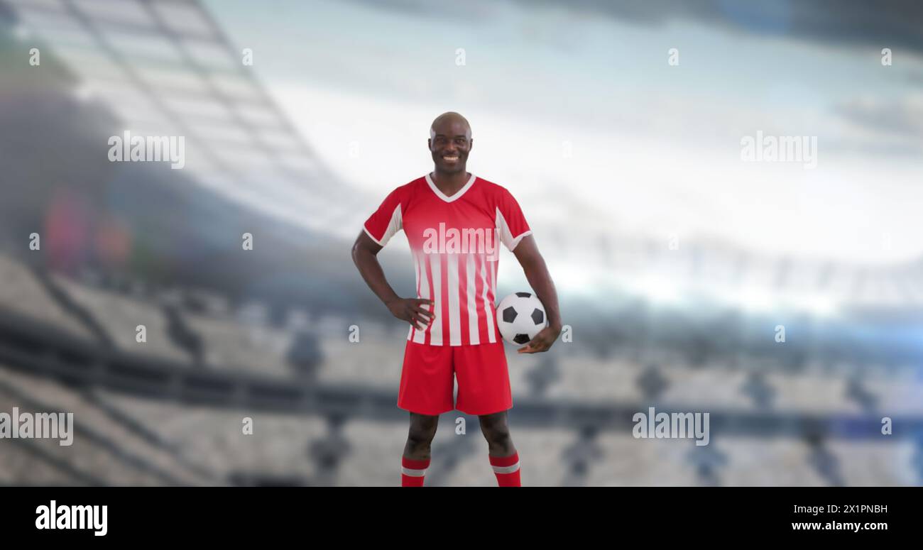 Mann in rot-weißer Fußballuniform, der Ball hält, auf einem Feld steht Stockfoto