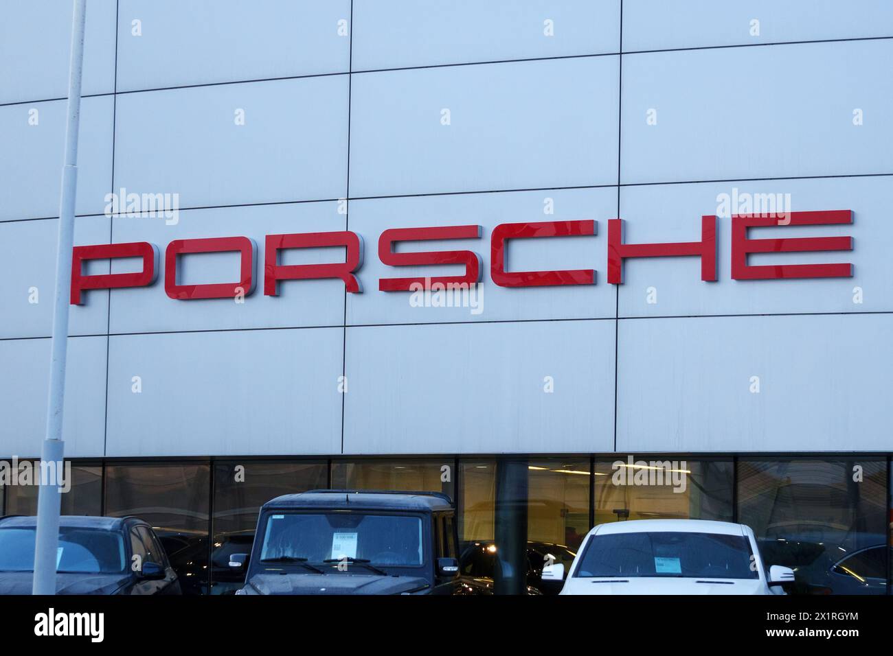 Tyumen, Russland, 18. März 2024: Fahrzeuge, die vor einem Porsche-Händlerbetrieb geparkt werden, zeigen Luxusautos und das ikonische Porsche-Logo. Stockfoto