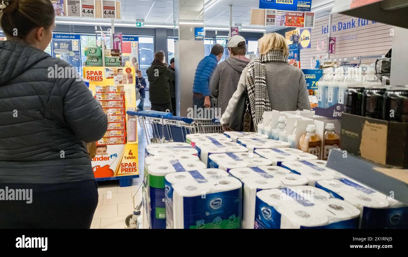 Hamburg, Deutschland. April 2024. Kunden, die an der Kasse in einem LIDL-Supermarkt stehen Credit: Markus Scholz/dpa/Alamy Live News Stockfoto