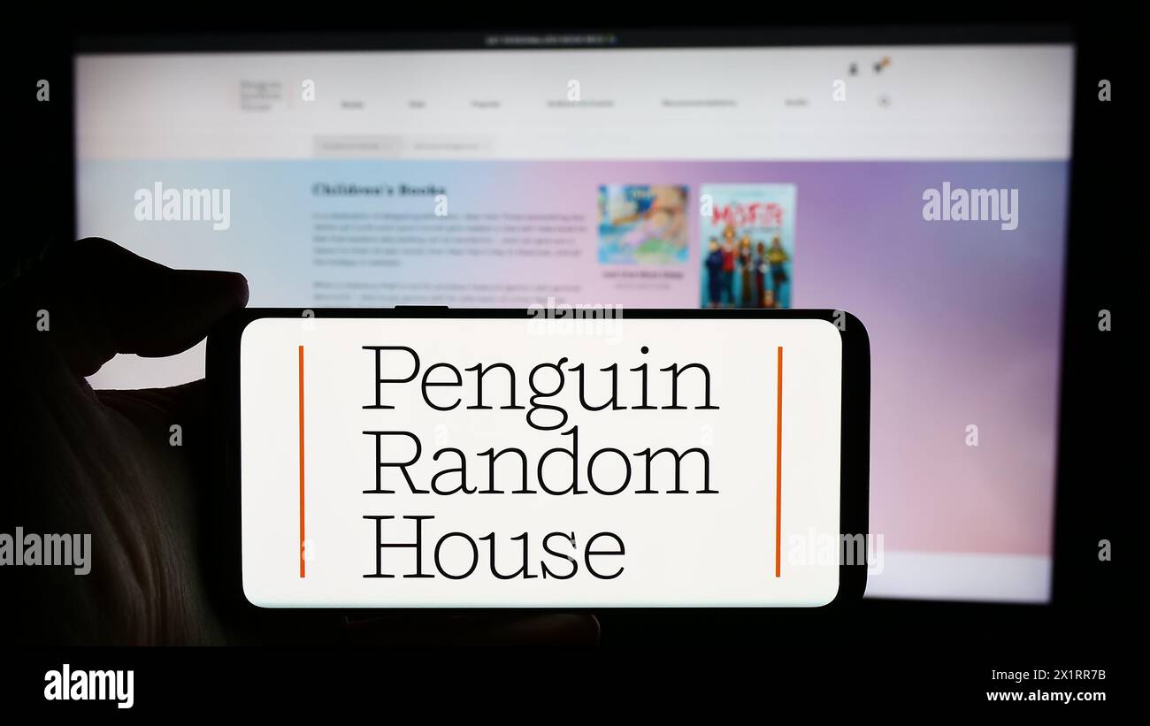 Person, die ein Handy mit dem Logo des US-Verlags Penguin Random House vor der Webseite hält. Schwerpunkt auf dem Display des Telefons. Stockfoto