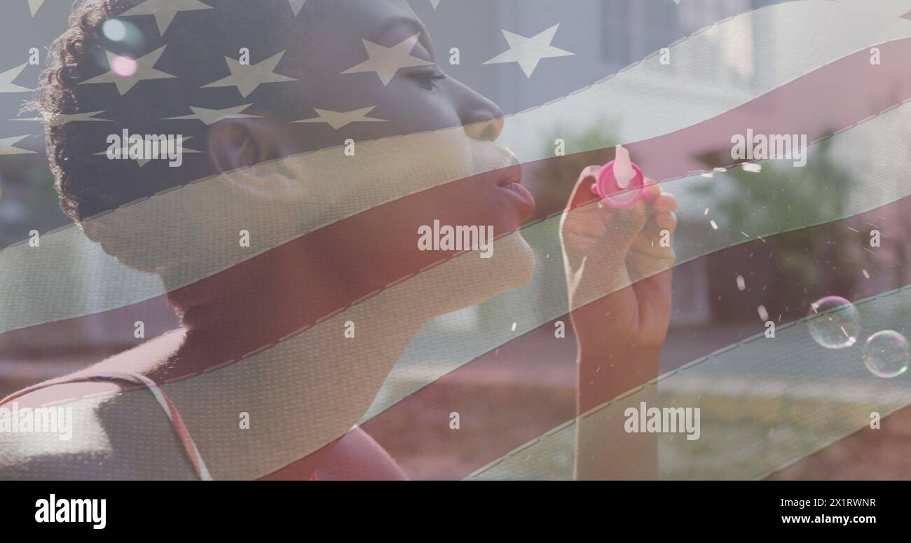 Afroamerikanischer junger Erwachsener, der Blasen bläst, überlagert mit US-Flagge Stockfoto