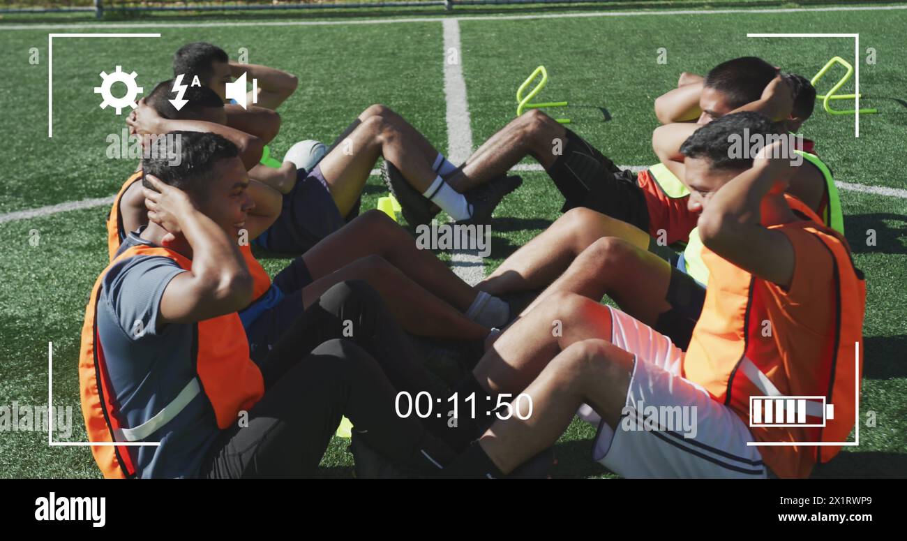 Gruppe von Biracial Athleten trainiert auf sonnigem Fußballfeld Stockfoto