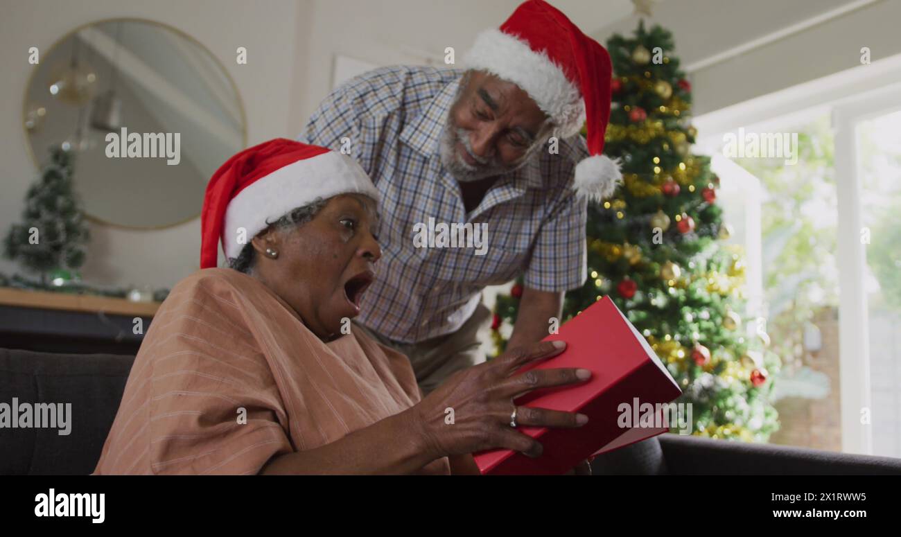 Seniorenpaar feiert Weihnachten, Großmutter Eröffnungsgeschenk Stockfoto