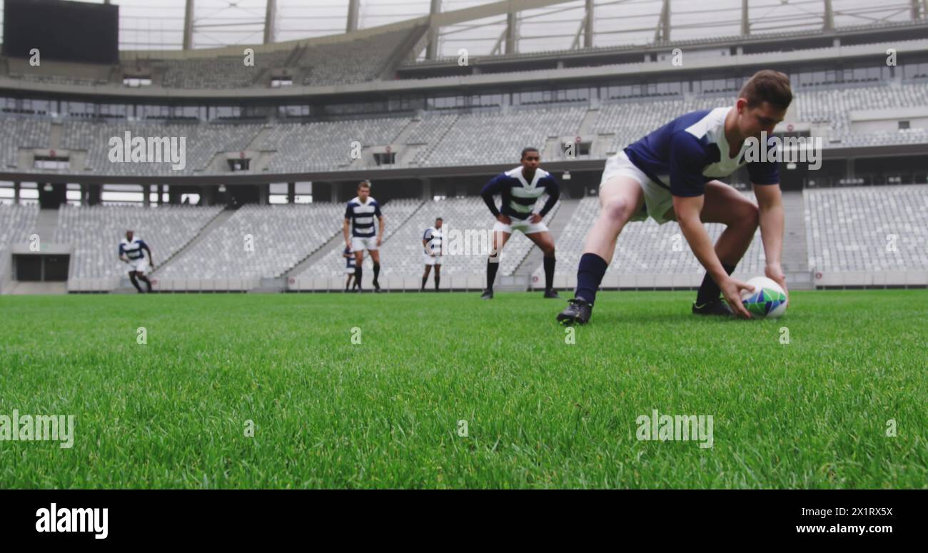 Gruppe von Freunden, die Rugby in einem großen Stadion spielen Stockfoto