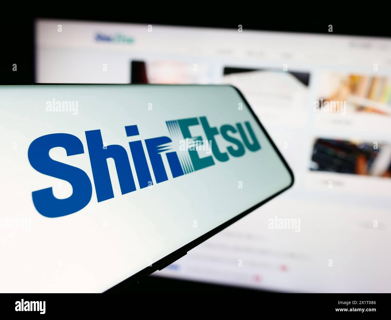 Handy mit Logo des japanischen Chemieunternehmens Shin-Etsu Chemical Co. Ltd. Vor der Business-Website. Fokus auf der linken Seite des Telefondisplays. Stockfoto