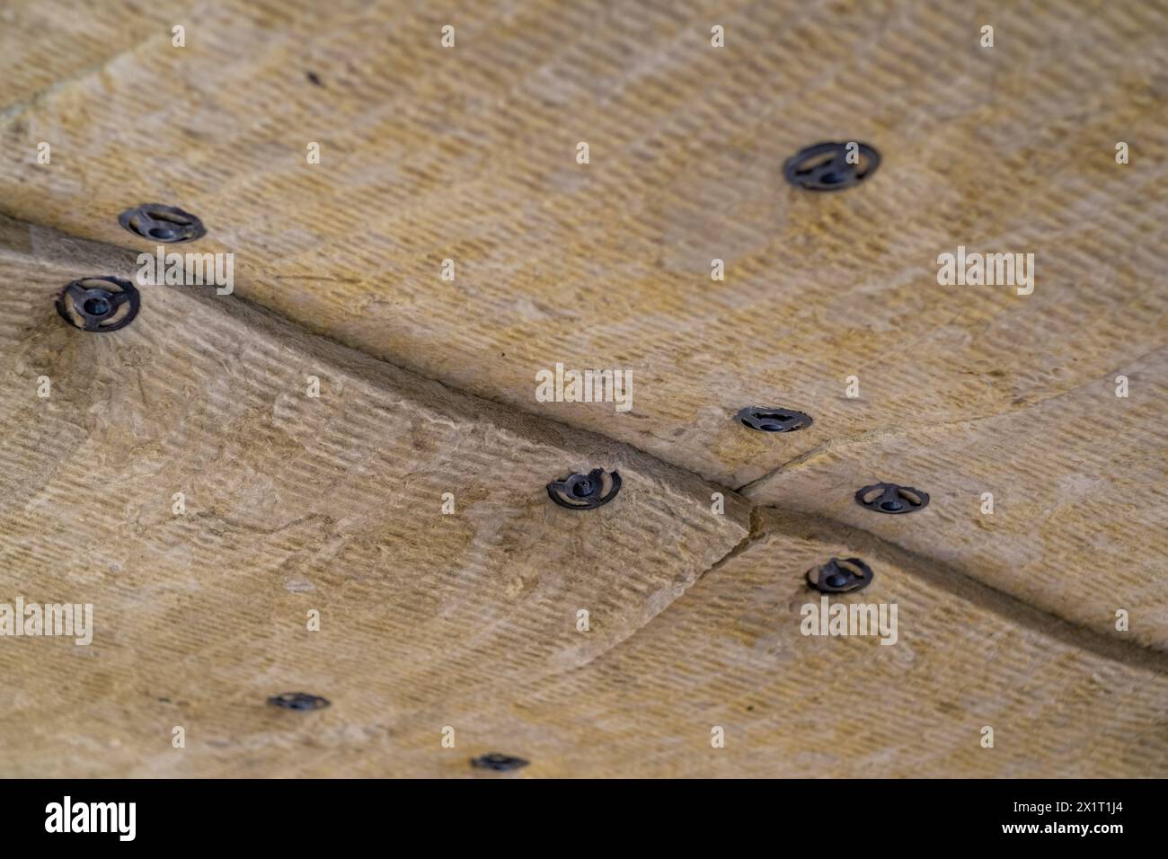 Dämmplatten aus Mineralwolle, die an der Decke verklebt wurden. Stockfoto