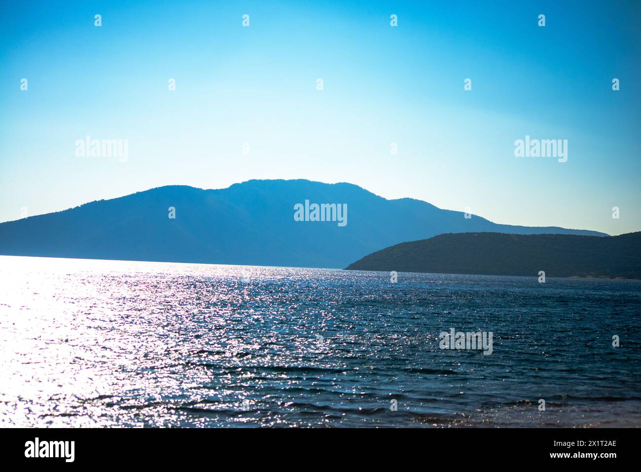 Tauchen Sie ein in die ruhige Schönheit der Küstenzone, wo das ruhige blaue Meer auf die Sandküste trifft. Stockfoto