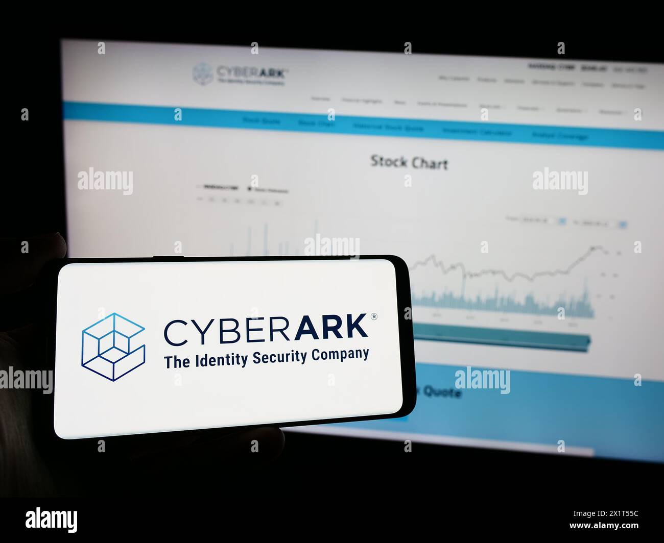 Person mit Mobiltelefon und Logo des amerikanischen Identitätssicherheitsunternehmens CyberArk Software Inc. Vor der Webseite. Schwerpunkt auf dem Display des Telefons. Stockfoto